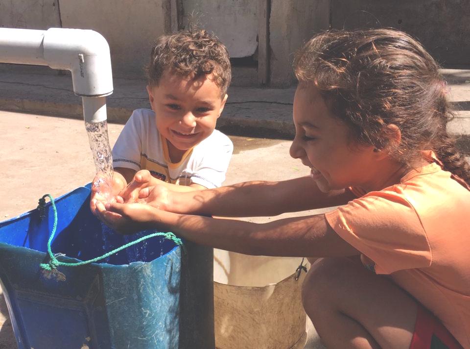 El Porvenir Hand Washing 2 kids wash their hands under a new pvc faucet